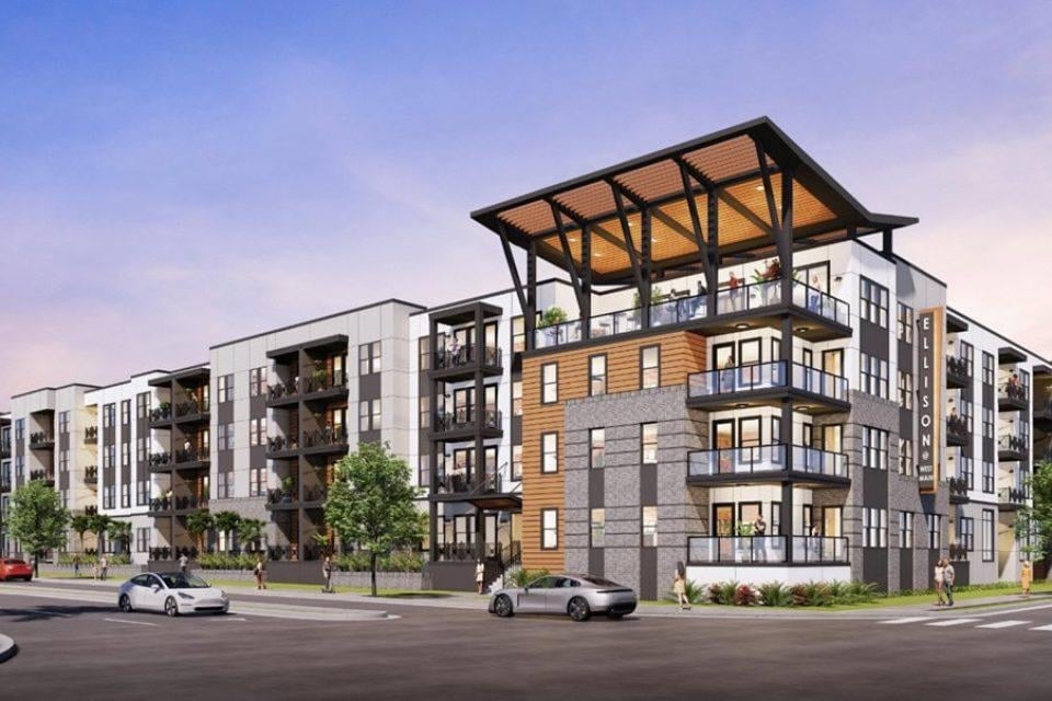 Modern multi?story apartment building with glass balconies and a large corner terrace.