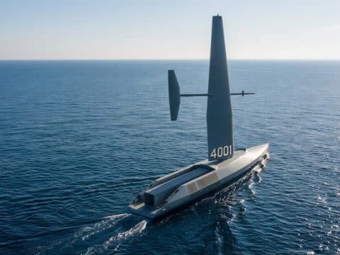 Autonomous hydrofoil sailboat with a tall vertical sail (number 4001) gliding across calm blue ocean.