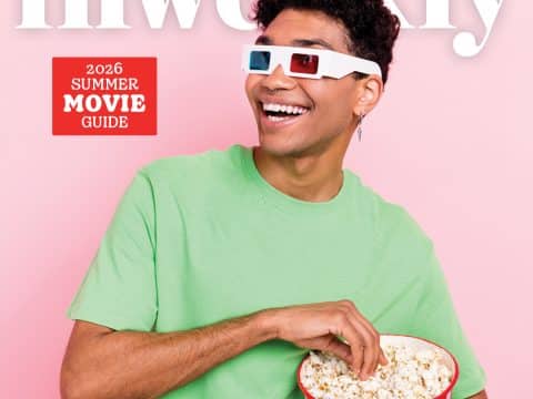Smiling man in a mint green shirt wearing 3D glasses holds a bucket of popcorn against a pink backdrop with a red 'Summer Movie Guide' badge.