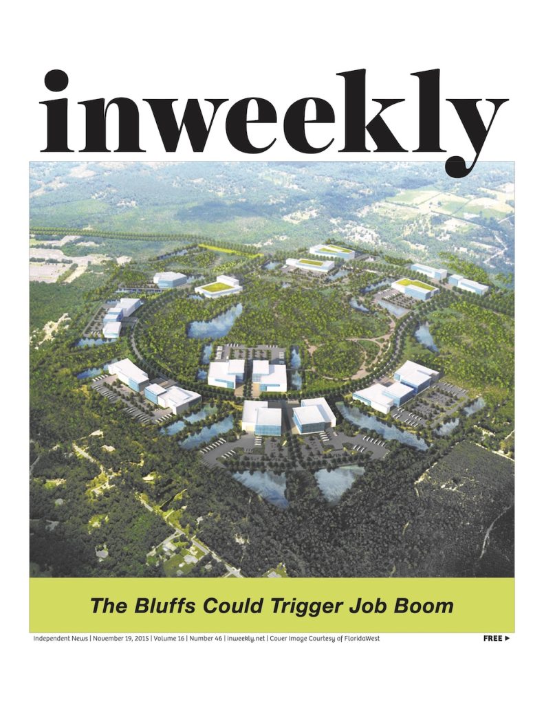 Inweekly magazine cover with an aerial view of a circular, campus-like development set in greenery and water; headline reads 'The Bluffs Could Trigger Job Boom'.