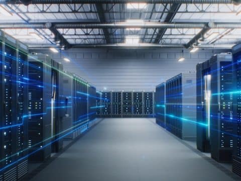 Data center with long rows of server racks and blue light streaks suggesting data flow.